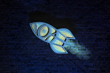 A rocket projected onto a brick wall, in blue and yellow