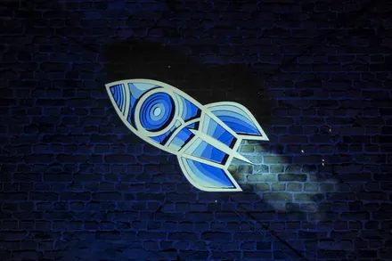 The same rocket on the brick wall, in teal and blue